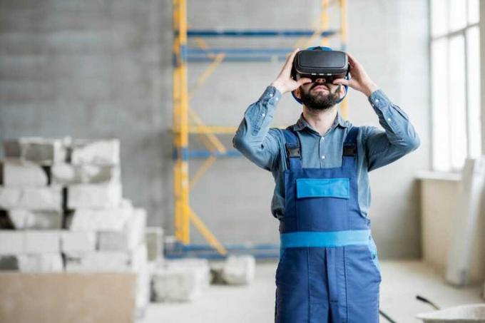 Строитель проецирует в очках VR будущий интерьер, стоящий на строительной площадке