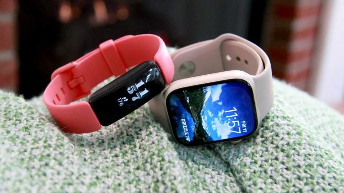 Fitbit Inspire 2 og Apple Watch 7 side om side på et tæppe