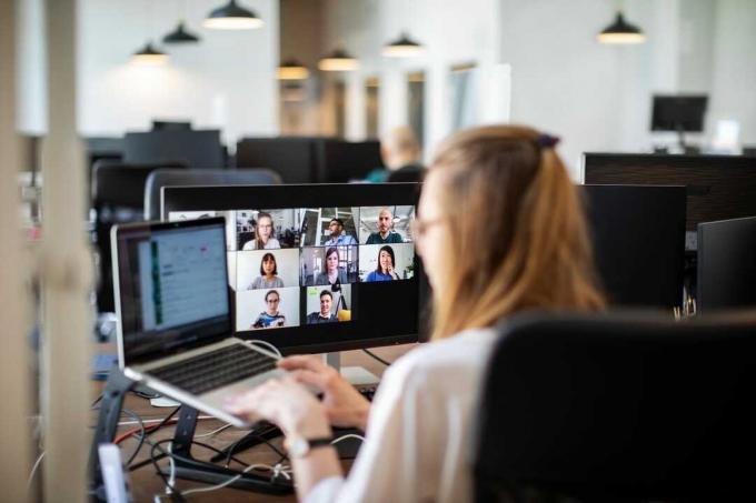 Frau bespricht Arbeit per Videoanruf mit Teammitgliedern im Büro